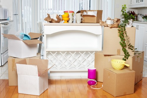 Professional movers carrying boxes and furniture from an Ealing home