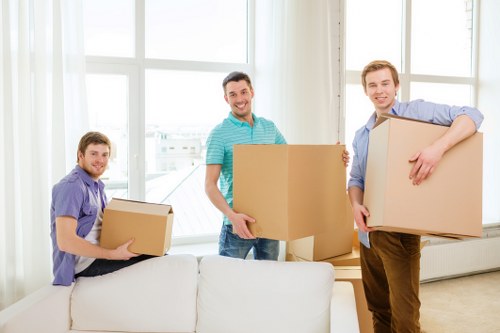 Local removals crew handling boxes and home furniture in West London